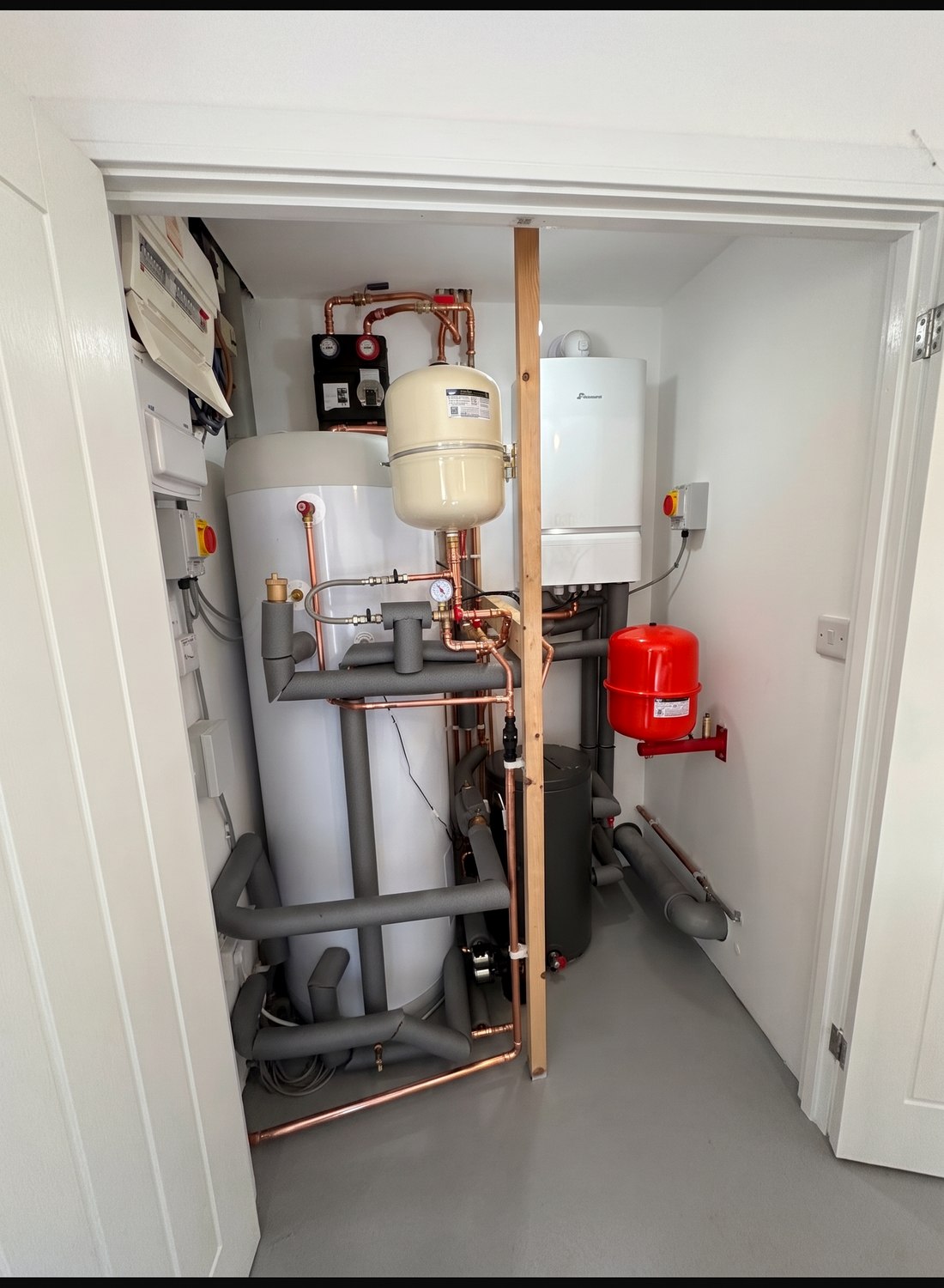 A new system boiler and unvented hot water cylinder installed together in an airing cupboard