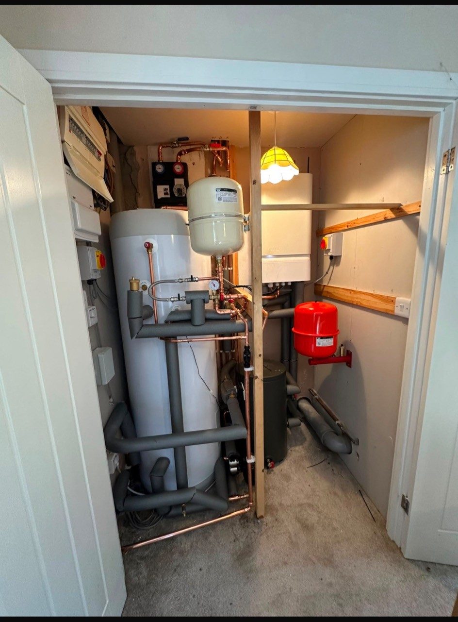 A new system boiler and unvented hot water cylinder installed together in an airing cupboard